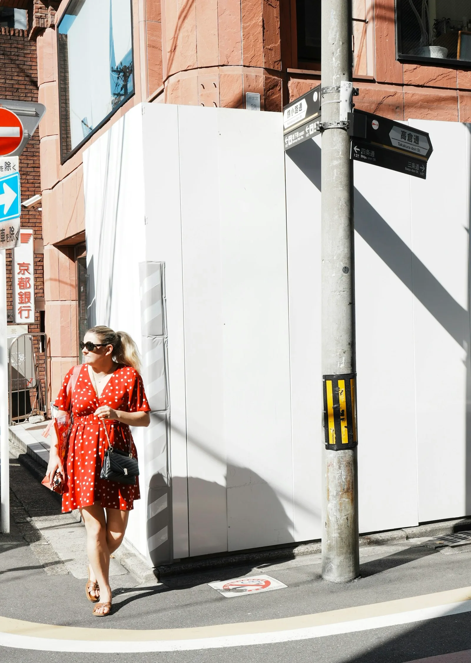A woman in red on a quiet street corner
