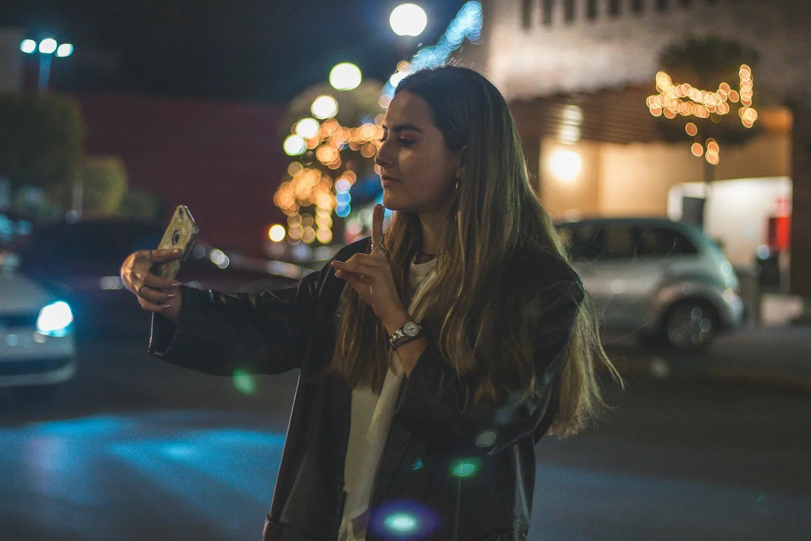 A woman on a night street, lit by soft lights