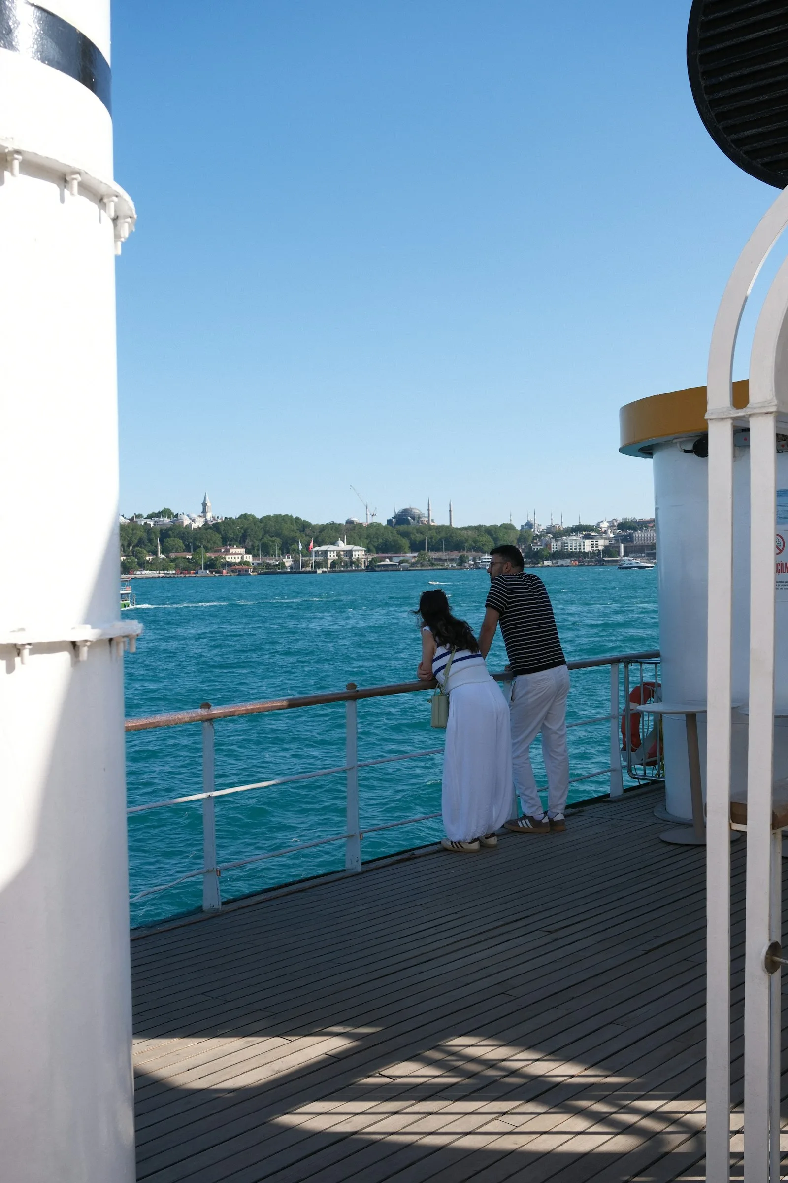 A couple on deck, the city behind them